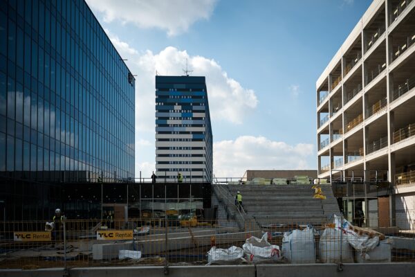 trzy nowoczesne, wysokie budynki, budynek po prawo bez okien